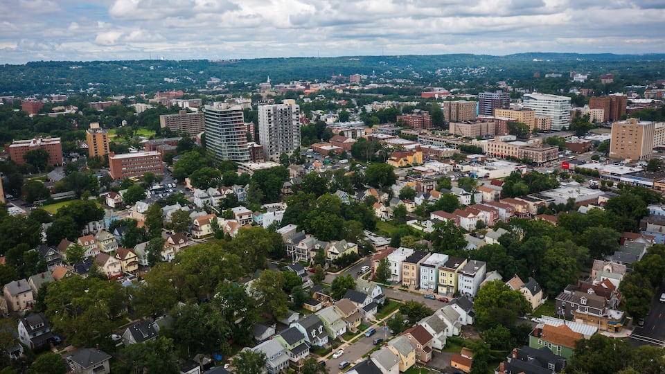 A cityscape with residential areas, commercial buildings, and a distant mountain range.