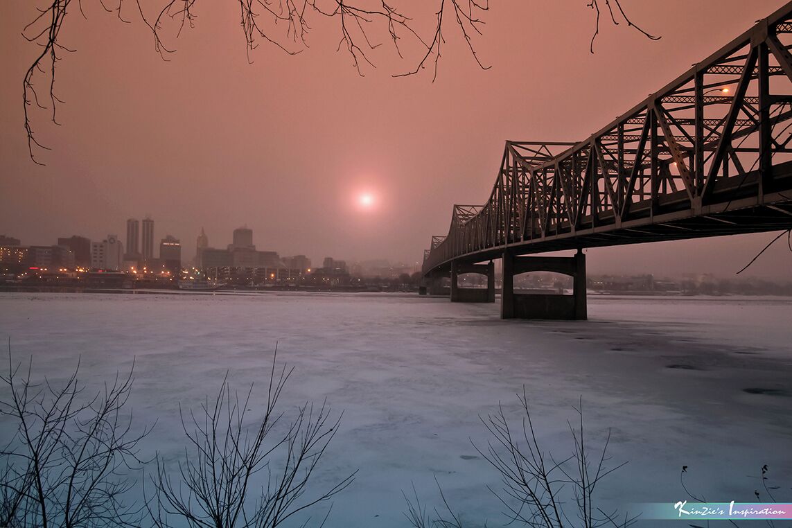 Rising Sun in Winter *A Popular Landmark*
#Murray Baker Bridge
#Peoria
#Chicago
#Illinois
#USA
#Sunrise
#Landscape

This location is the highest crime area in Peoria, actually I put myself in high risk while capturing this photo. That day I arrived this place at 5am in early morning purposely waited for sunrise, the temperature was so cold and below zero. A patrol car suddenly stopped me, the police officer asked me to leave this place immediately. I told the police officer "Please allow me to take at least one sunrise photo, I spent 3 hours drove from my home to here". Ended up the police officer accompany me for protection till I done, really thanks to the police officer :) Rising sun at dawn in winter, photo captured in a freezing cold morning under Murray Baker Bridge, Peoria Illinois USA. 

Photo Licensed by iLOVEnature's Photography Inspiration l All rights reserved