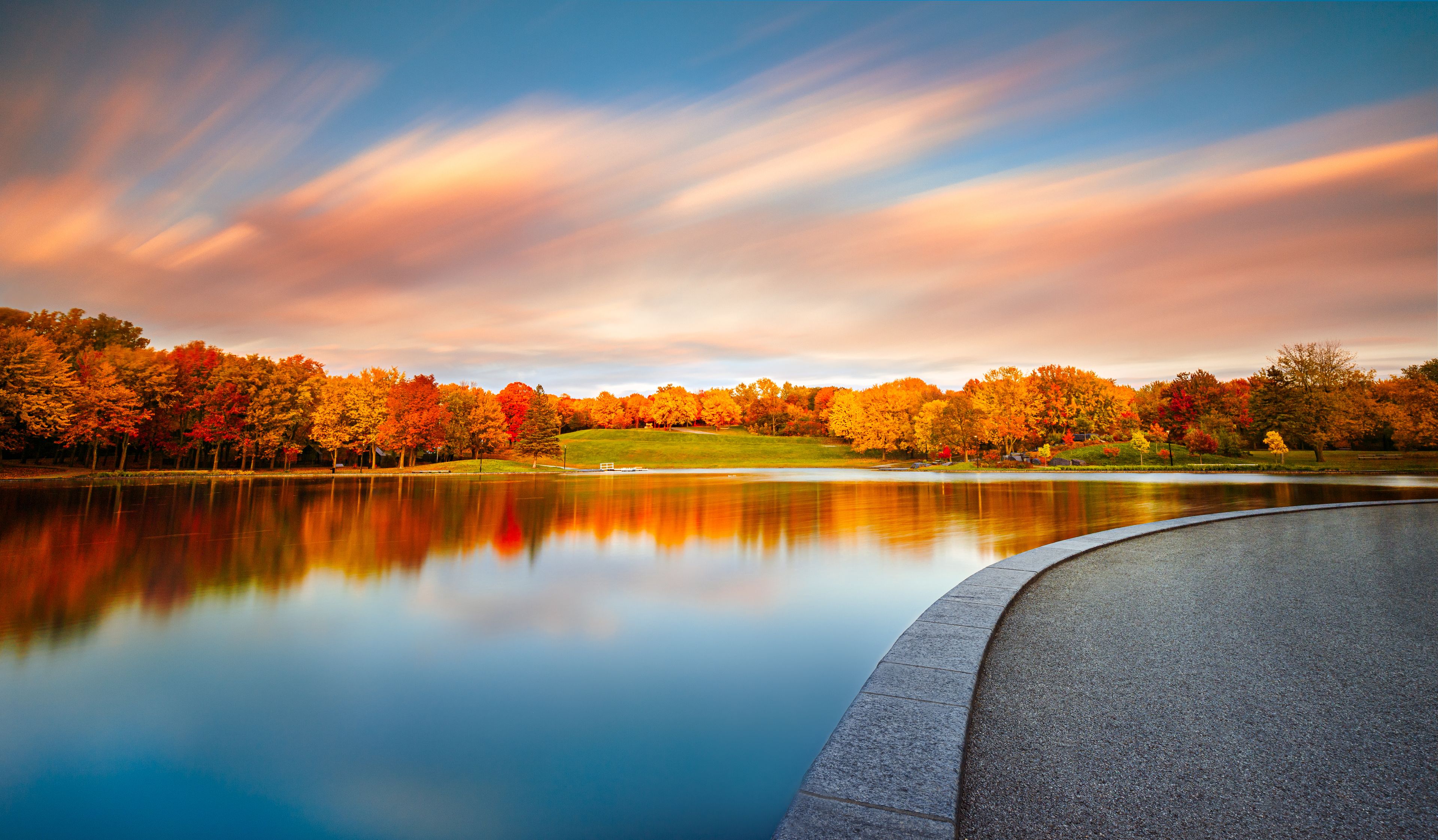 Beaver Lake / Lac Aux Castors in Montreal, Quebec, Canada in Peak Fall Colors at Sunset with Orange Clouds