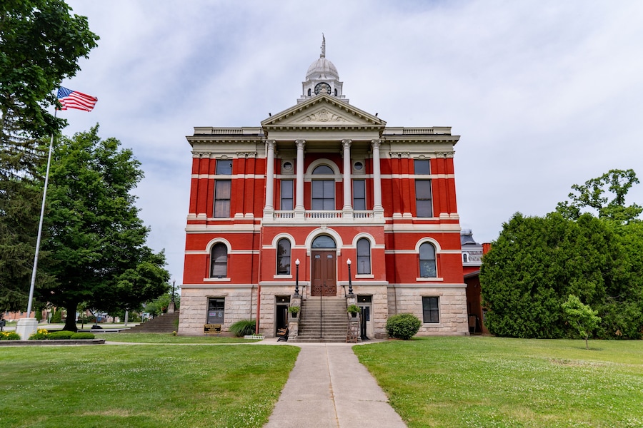 A large red and white building with a central dome and a flagpole with an American flag.