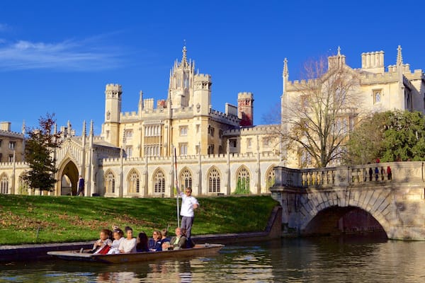 A historic building with intricate architecture, a river, and a bridge.