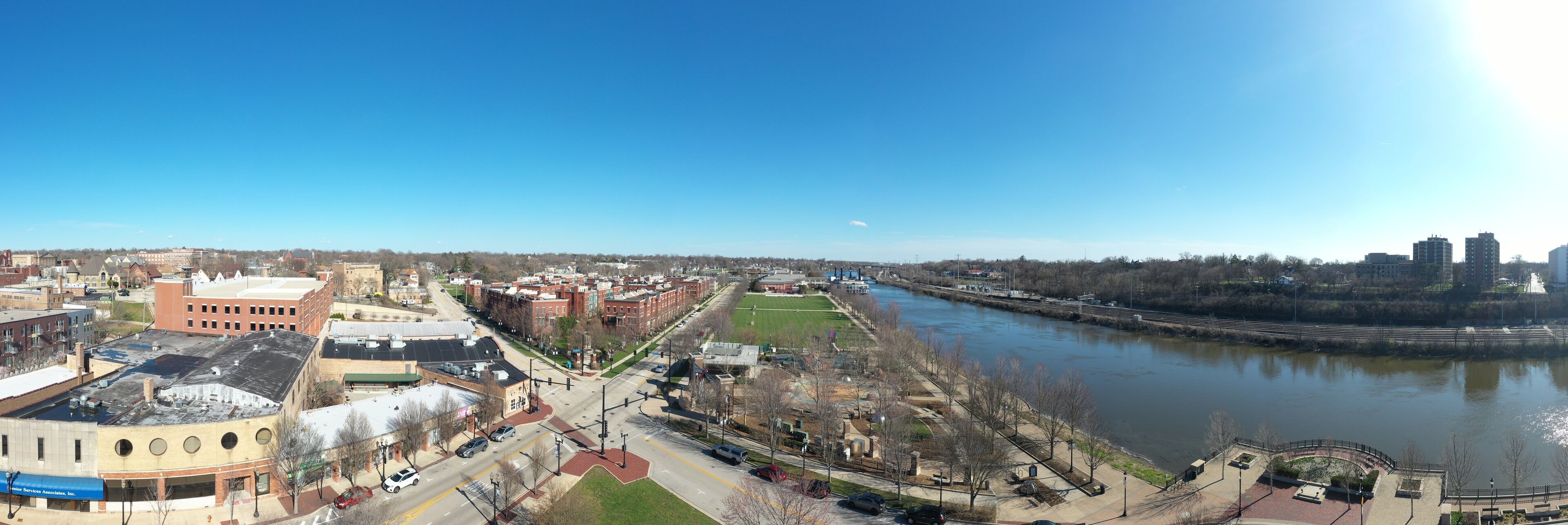A river with a bridge, a park, and buildings along the riverbank.