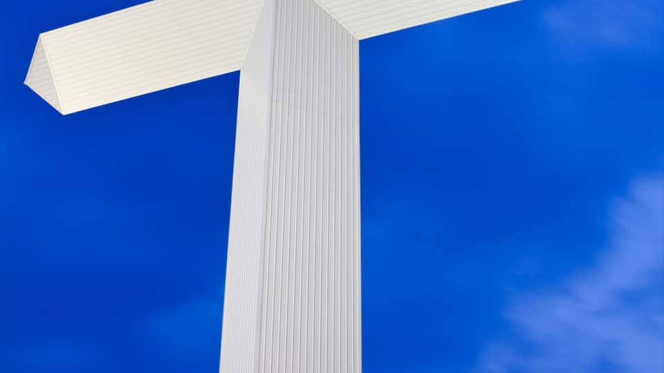 A large white cross against a blue sky.