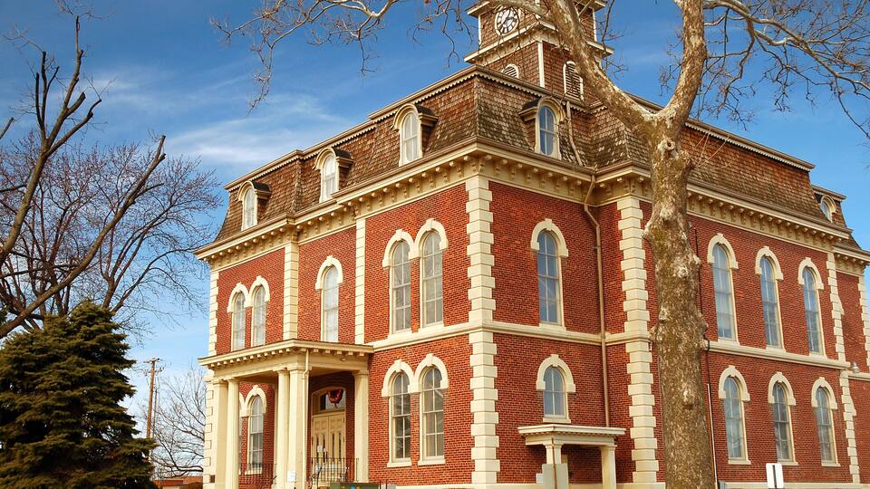 A large red brick building with white trim and arched windows.