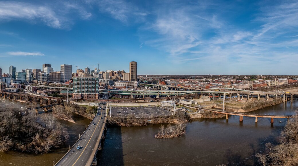 Aerial panorama of Richmond Virginia views of the Mayo and Manchester bridge over the James river, floodwall, industrial railroad tracks, downtown business district, Shockoe slip, capitol district