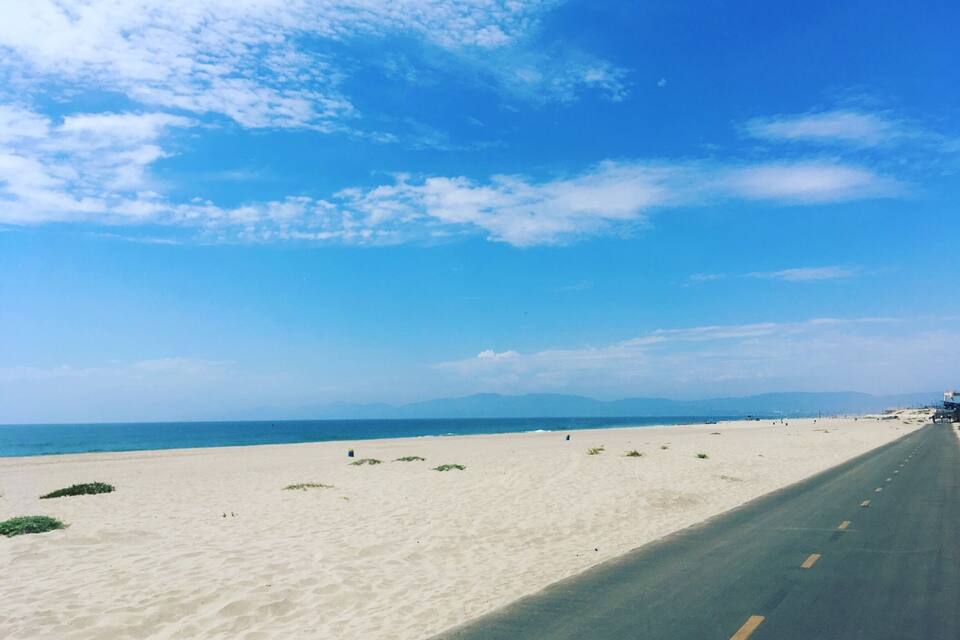 Una playa con una carretera que la bordea.