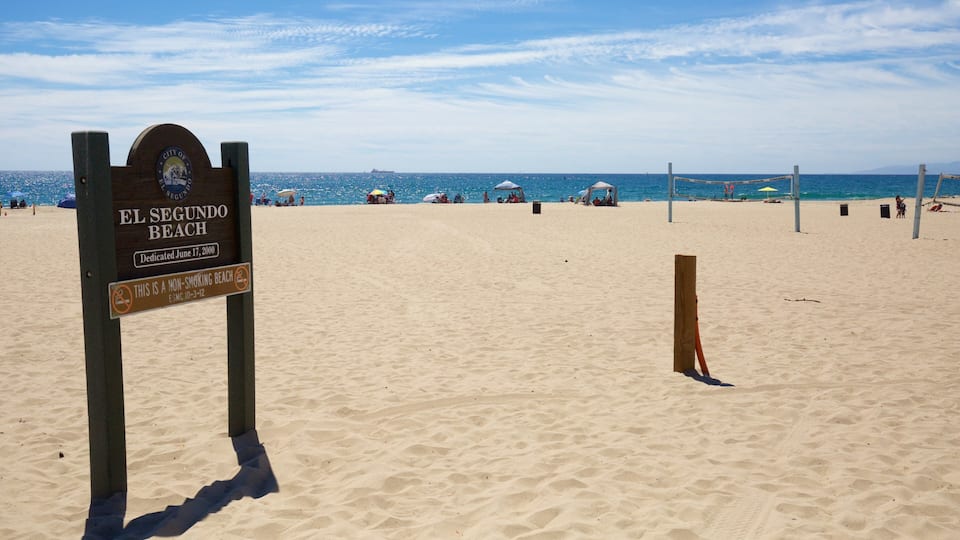 A beach with a sign reading "El Segundo Beach" and "Dedicated June 17, 2000".
