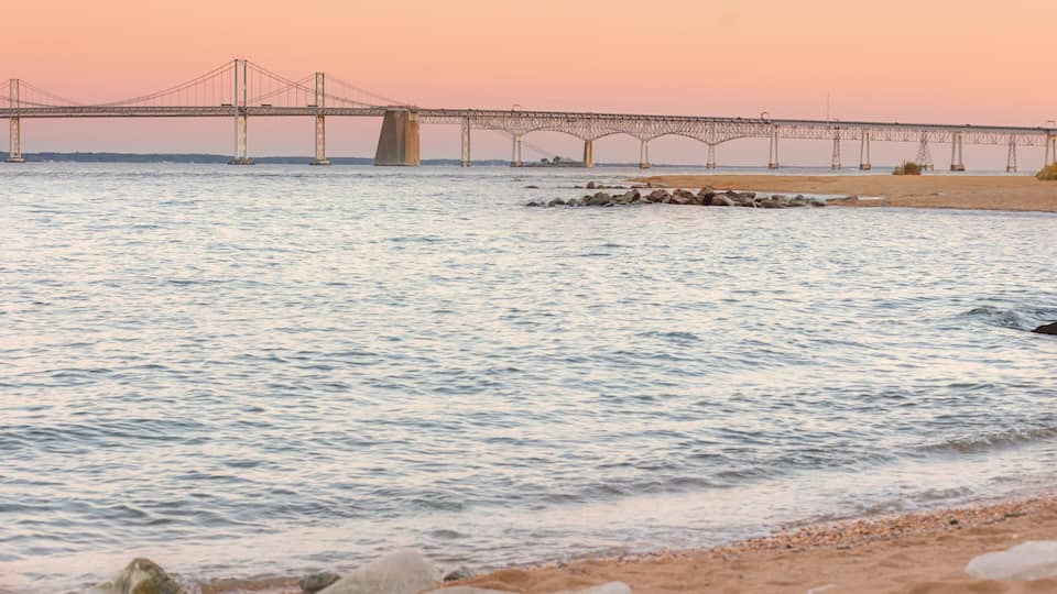 A bridge over a calm river at sunset.