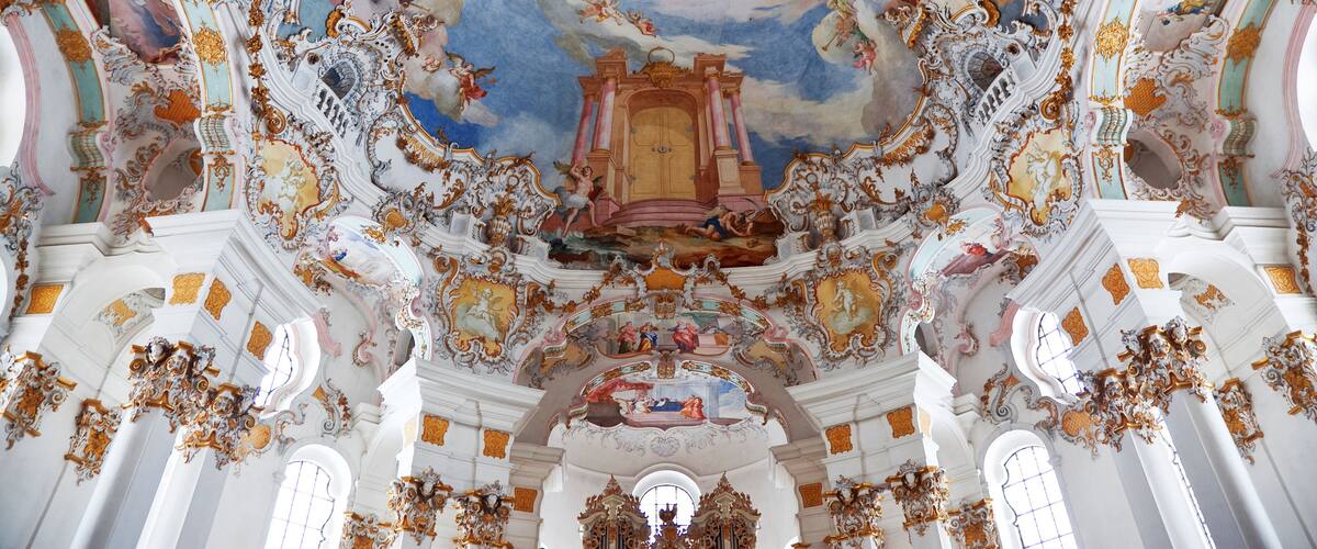 An ornate ceiling with elaborate frescoes and gilded decorations.