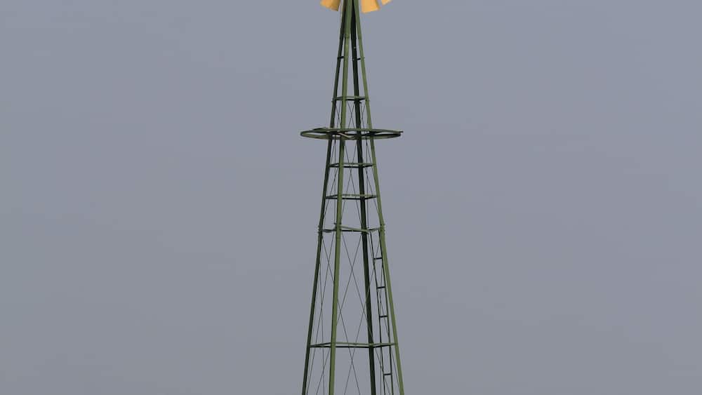 windmill in the field with green grass south of Ellsworth Kansas USA with blue sky.