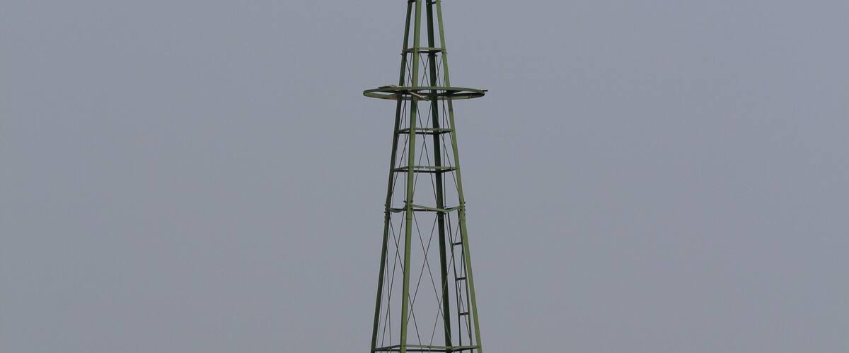 windmill in the field with green grass south of Ellsworth Kansas USA with blue sky.