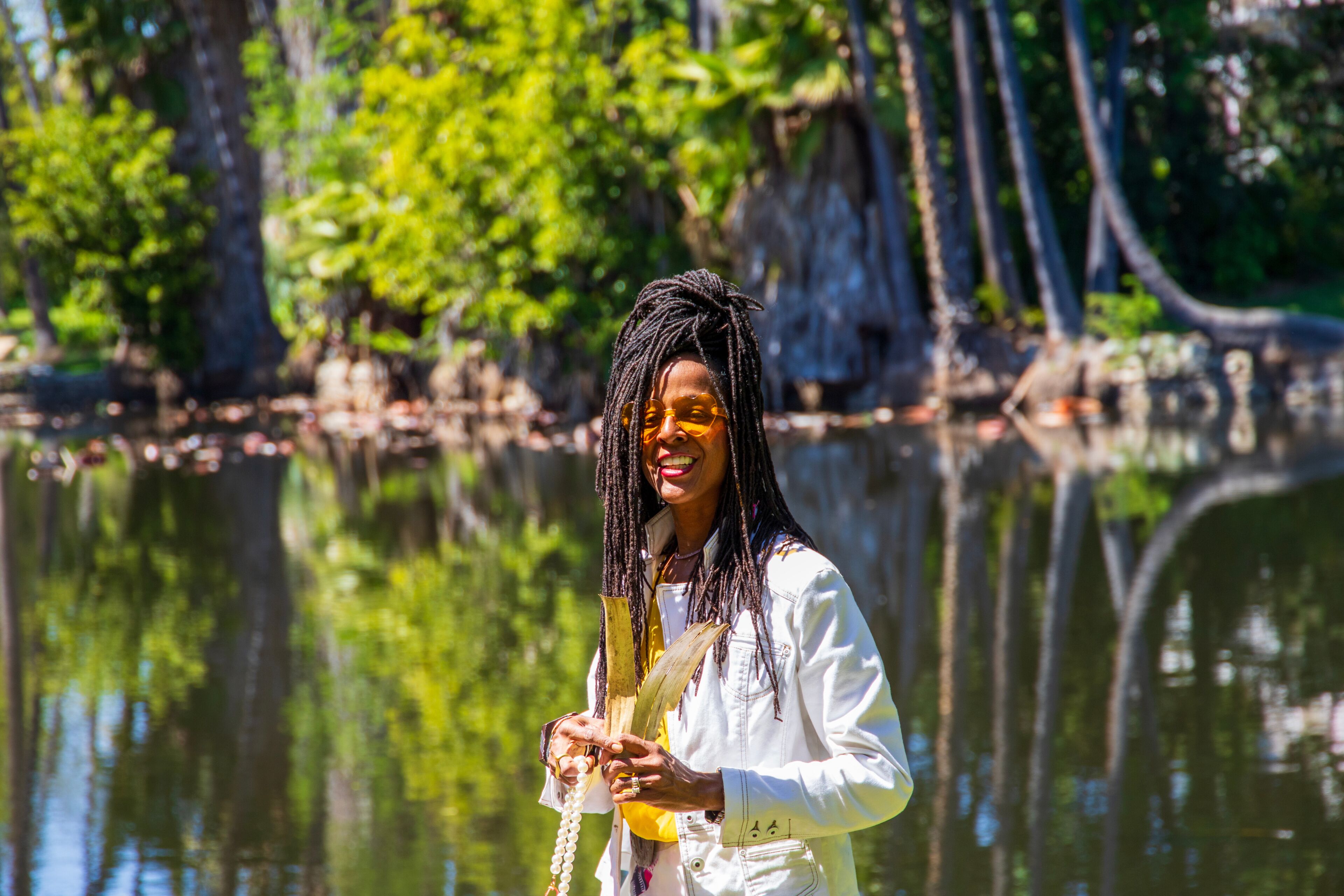 An African American woman with sister locks in a gorgeous landscape at the Los Angeles County Arboretum and Botanic Garden in Arcadia California USA