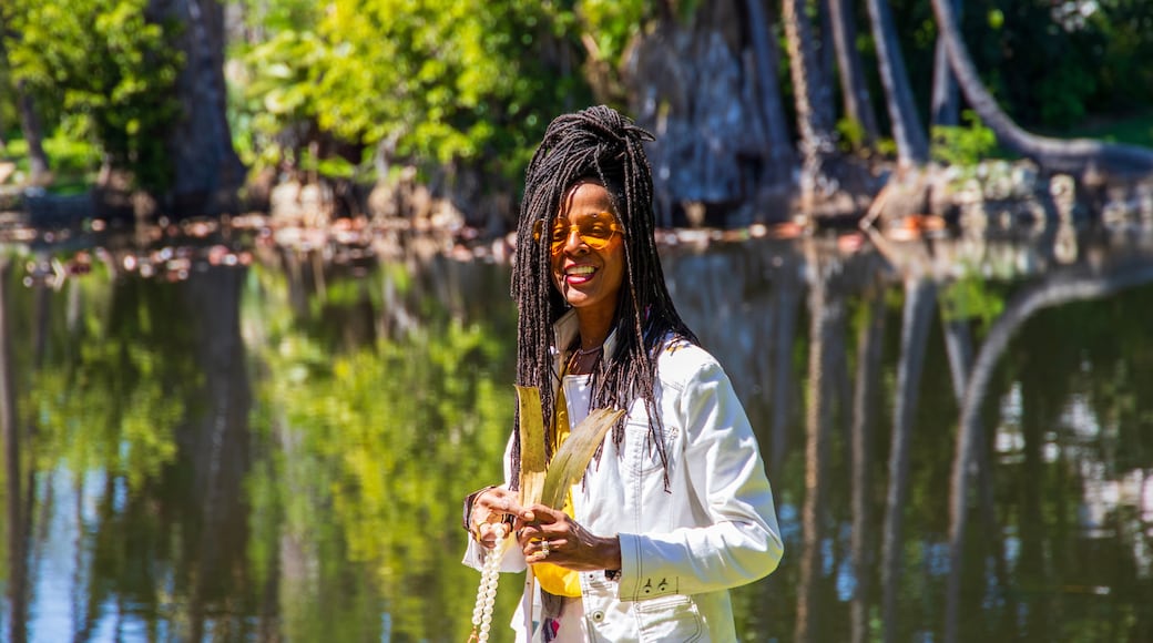 An African American woman with sister locks in a gorgeous landscape at the Los Angeles County Arboretum and Botanic Garden in Arcadia California USA