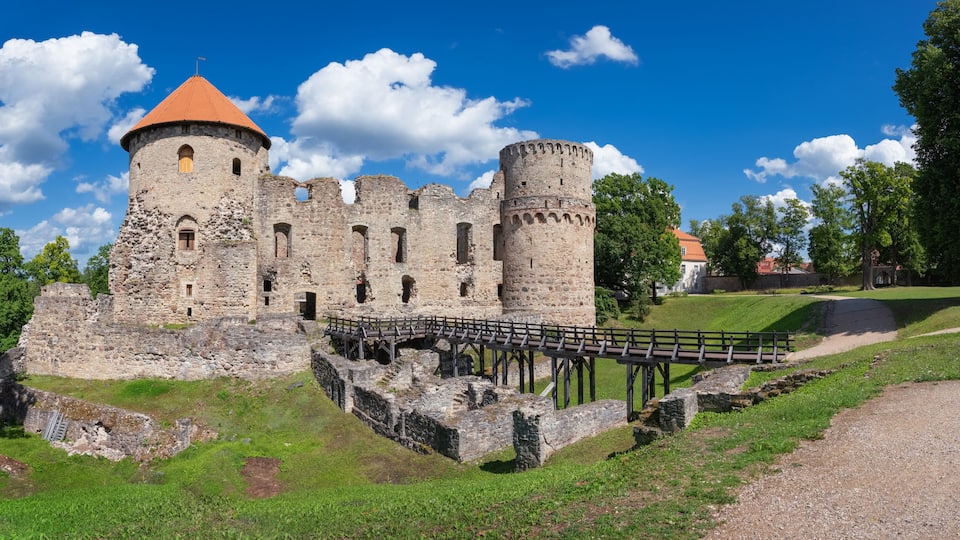 A medieval castle with a round tower, a bridge, and a moat.