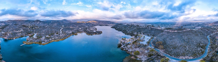 A large body of water surrounded by mountainous terrain with winding roads.