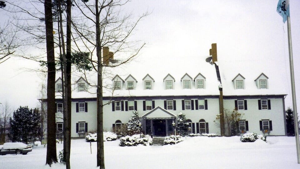 A large, two-story building with a symmetrical facade, multiple windows, and a central entrance.