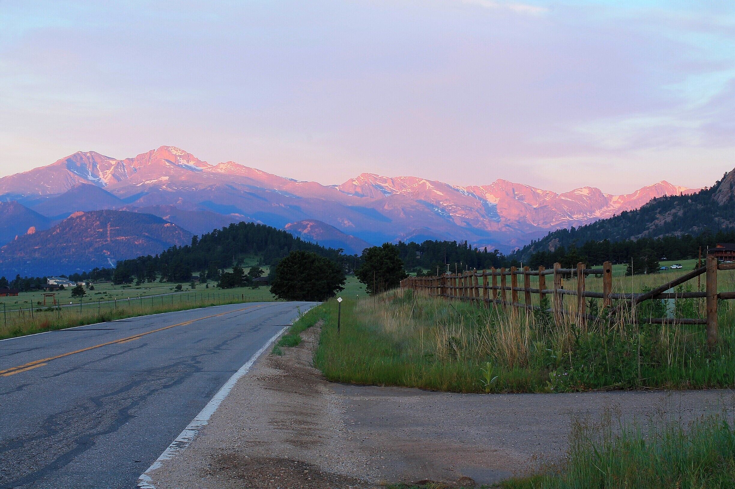 Traveling on Devil's Gulch Road, towards Estes Park, you get this fantastic view of the sunrise on the Rocky Mountains. It's beautiful, with the farms, hills, and rock formations surrounding you and those incredible mountains in front of you! #RockyMountainNationalPark #rockies #mountains #colorado #EstesPark  #sunrise #colorful #EndlessSummer #blue #Perspectives