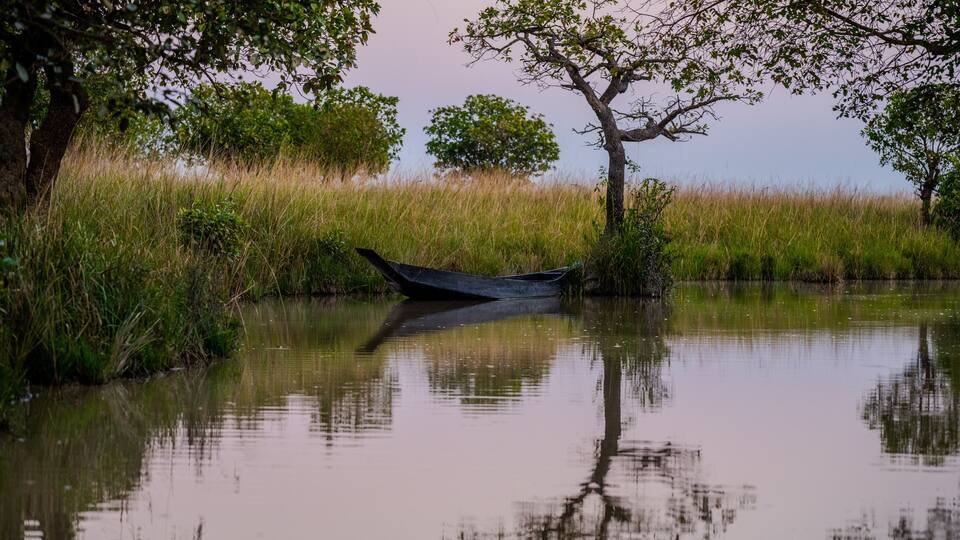 Serene Wetland Landscape with Traditional Wooden Boat at Dusk in Gowainghat, Sylhet, Bangladesh