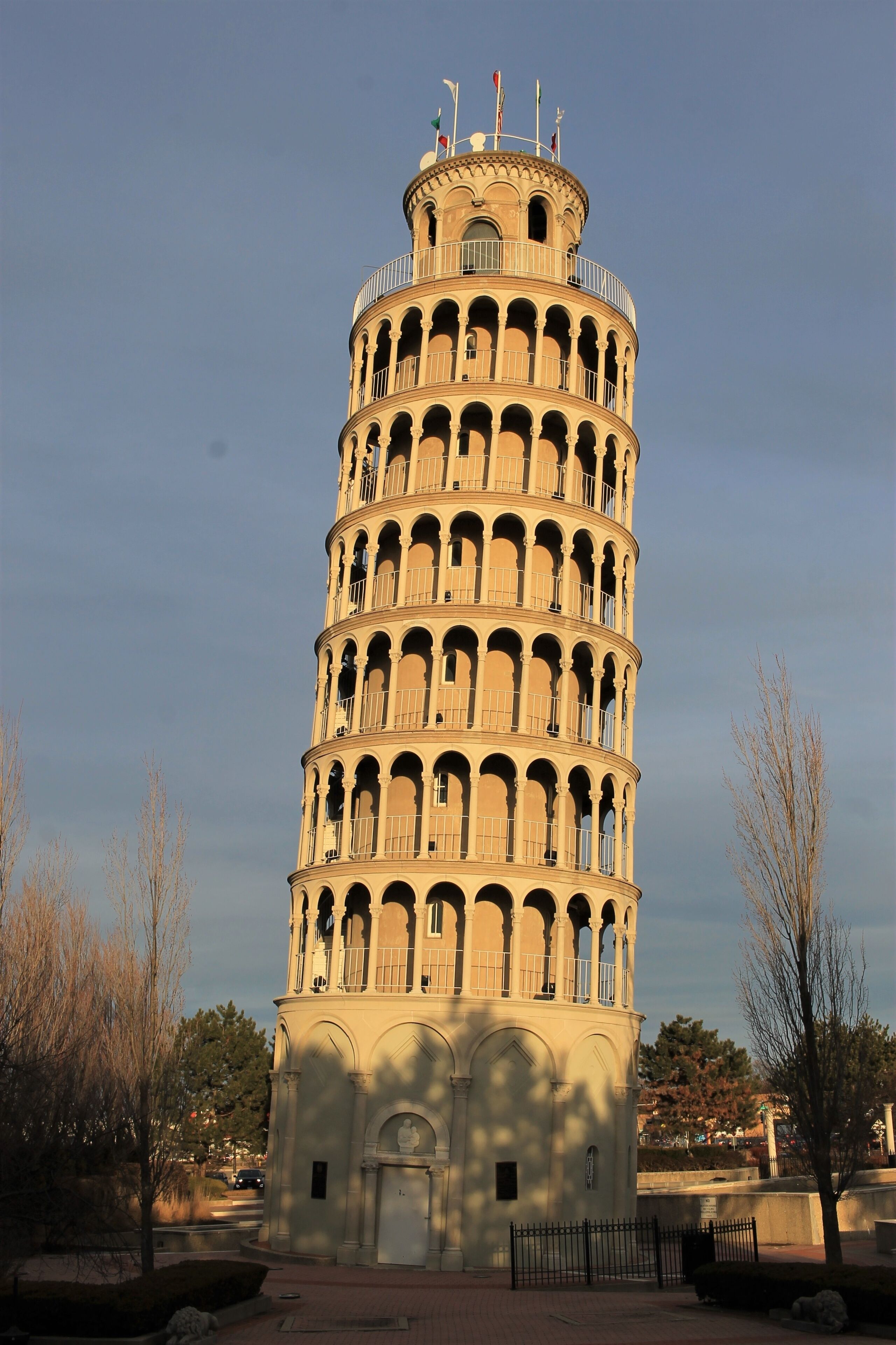A tall, cylindrical tower with multiple balconies and a flag on top.