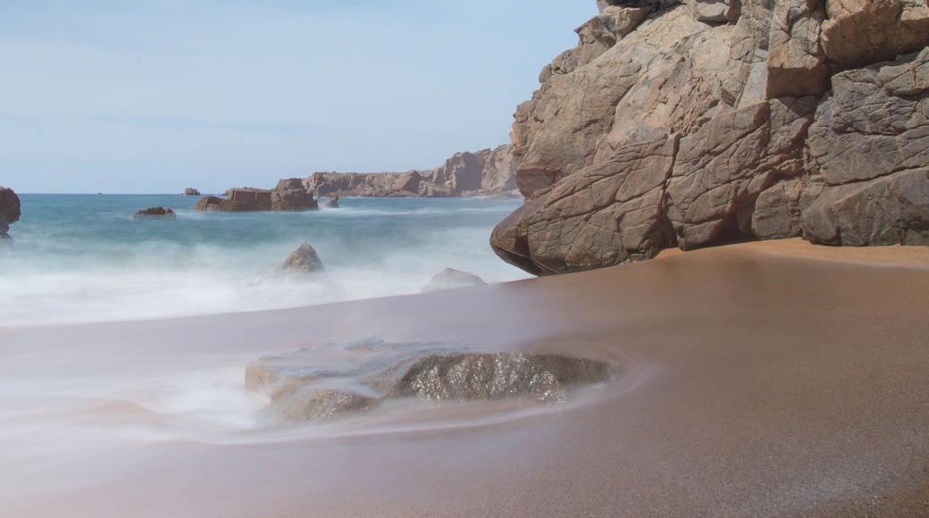Une plage avec de gros rochers et des vagues.