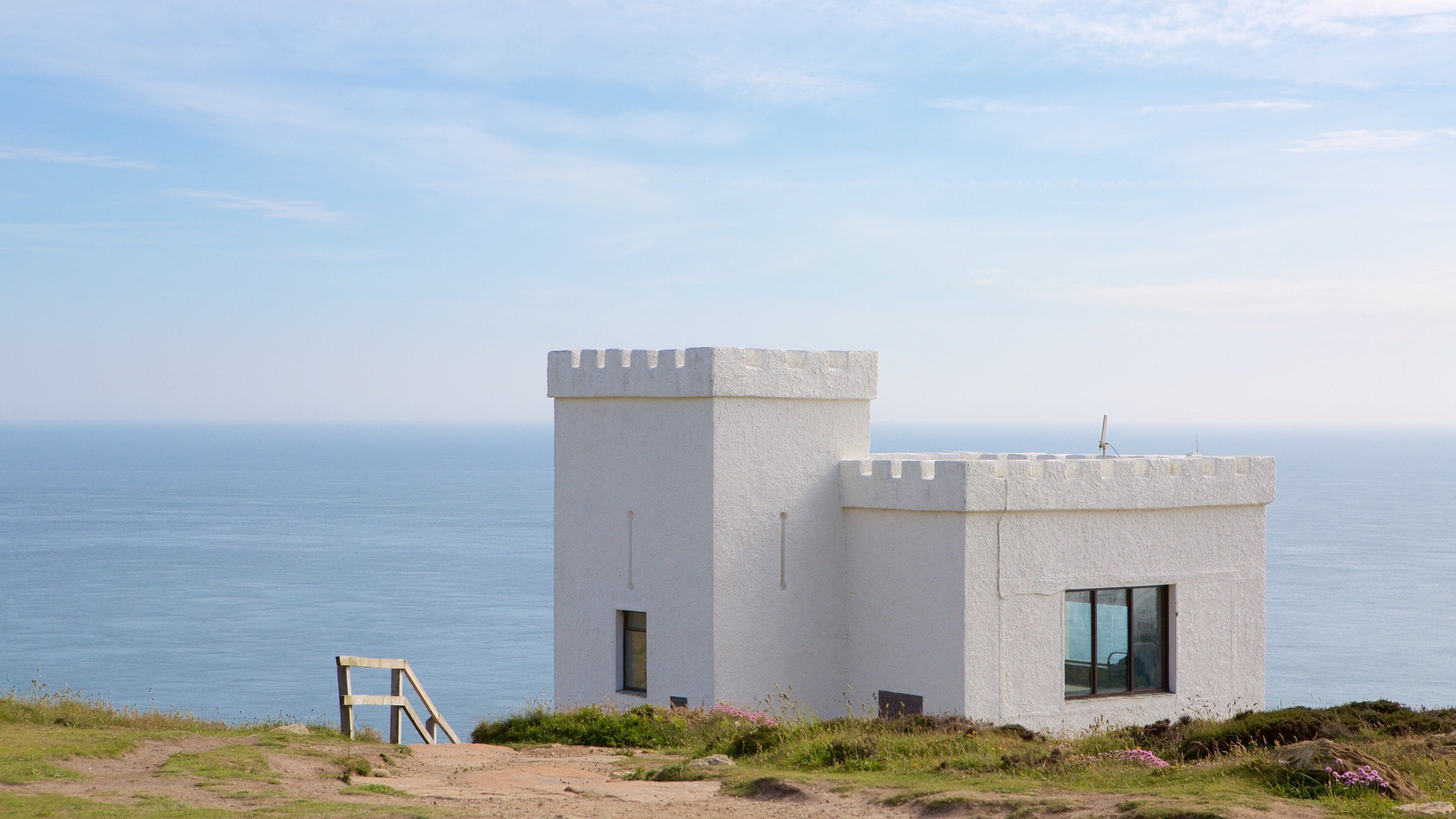 A coastal tower with a ladder, overlooking the sea.