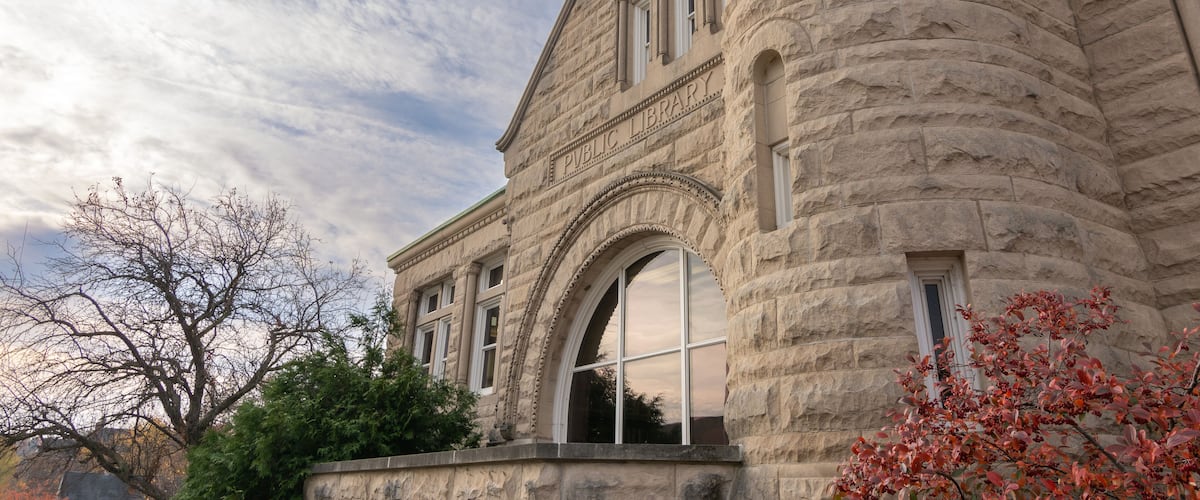 A historic stone building with arched windows and a clock tower.