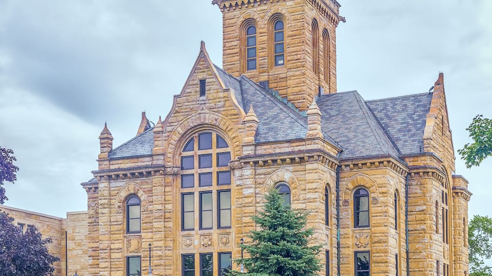 A large stone building with a clock tower and arched windows.
