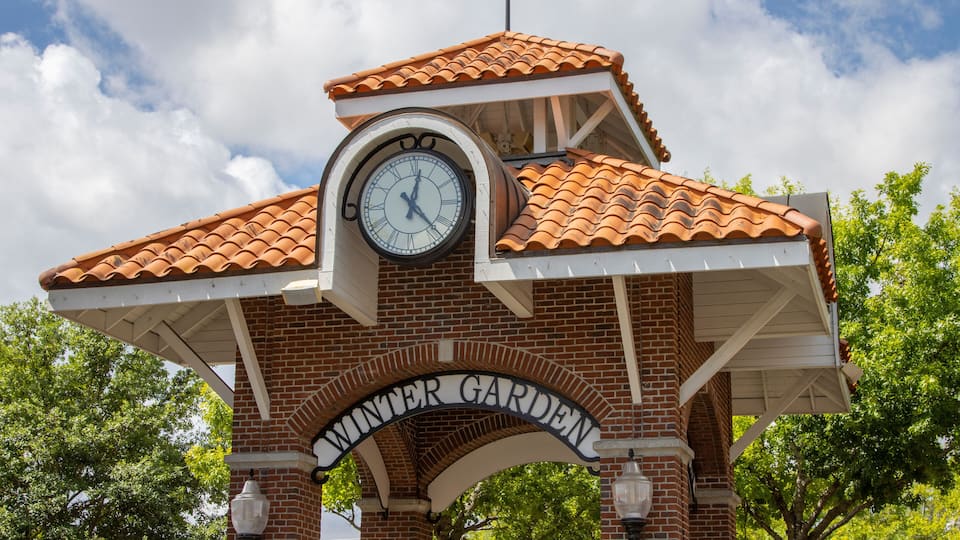 A clock tower with the inscription "Winter Garden" on a brick structure with a tiled roof.
