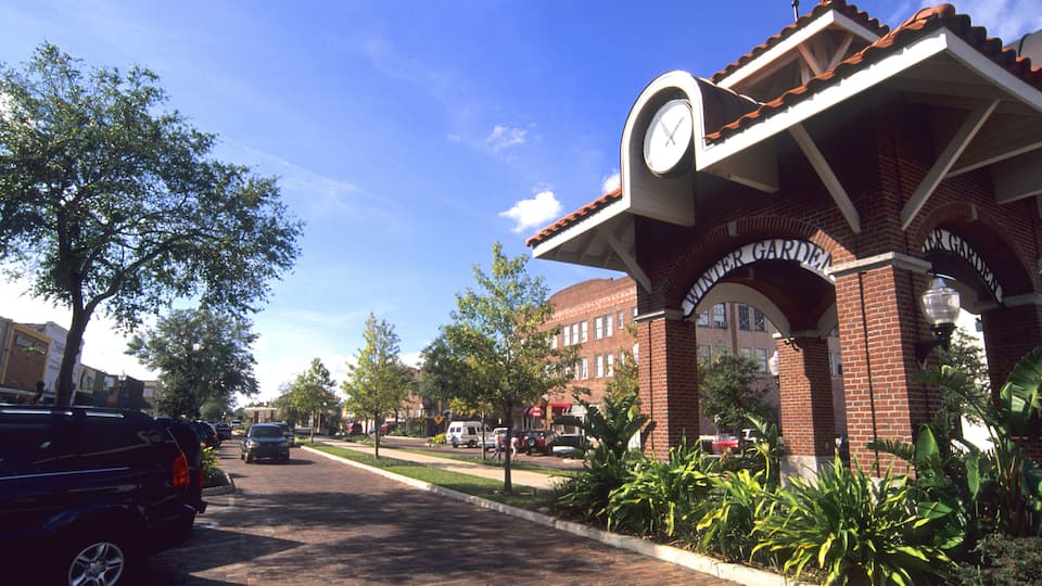 A brick building with a clock tower and a sign that reads "Winter Garden."