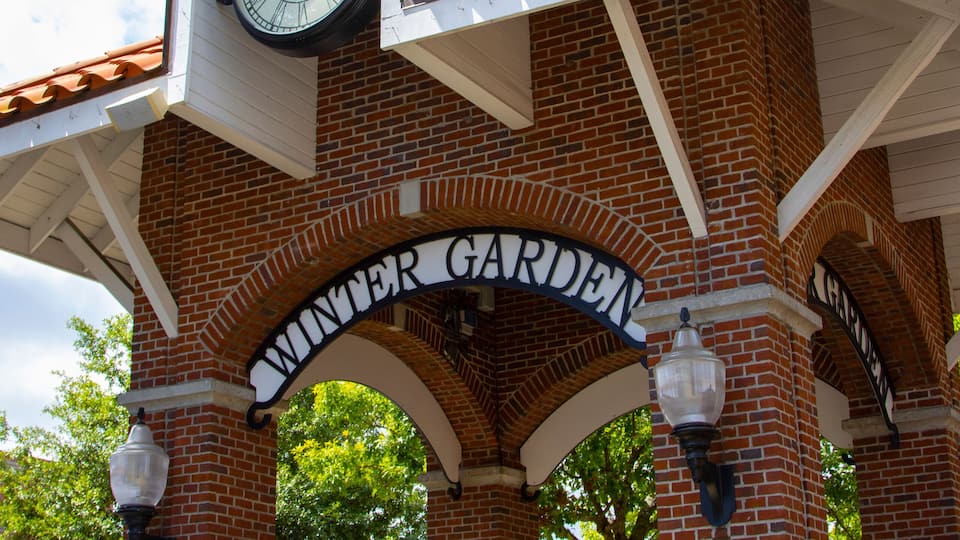 A brick structure with a clock and the words 'WINTER GARDEN' on it.