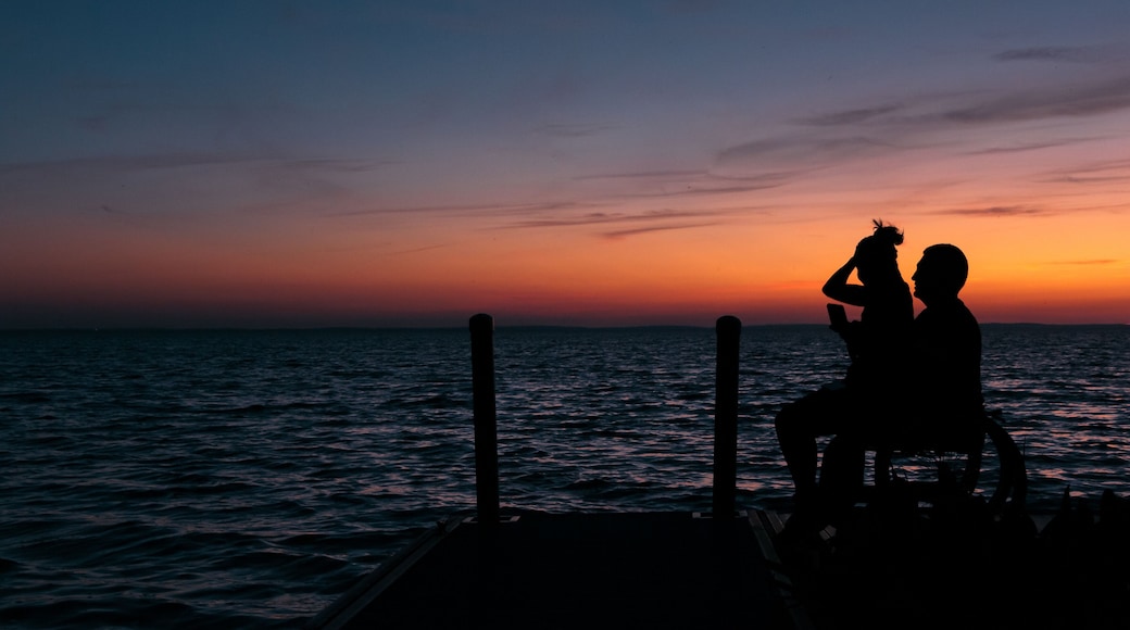 Silhouette of a disabled young man and his girlfriend in a wheelchair enjoying the sunset over Lake Apopka near Orlando, Florida.