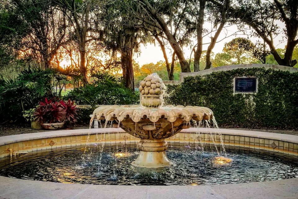 Une fontaine dont l’eau jaillit du sommet, entourée d’une piscine circulaire.
