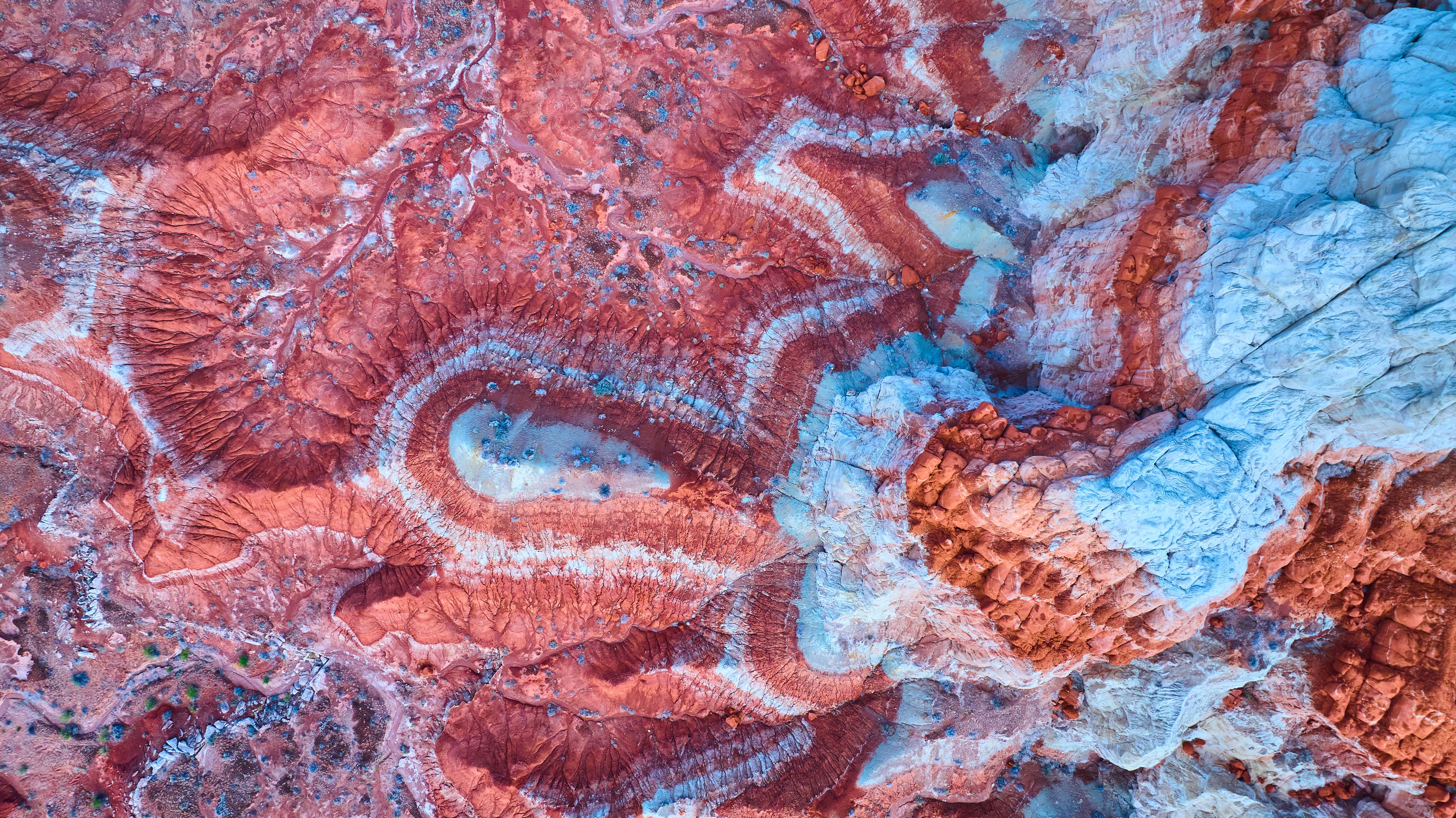 A close-up of a rock formation with red, white, and blue colors.