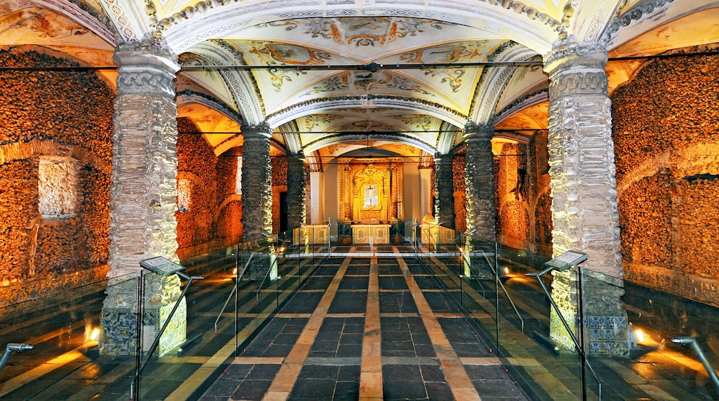 An ornate interior with a central altar, stone columns, and a patterned floor.