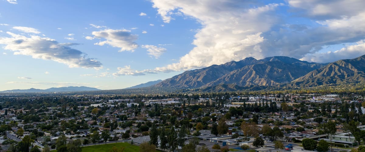 A town nestled at the base of a mountain range with a clear sky.