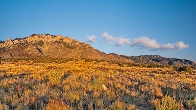 Uma cordilheira com vegetação escassa e céu claro.