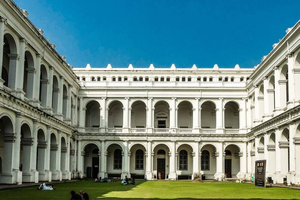 Un grand bâtiment blanc doté de nombreuses arcades et d’une cour intérieure.