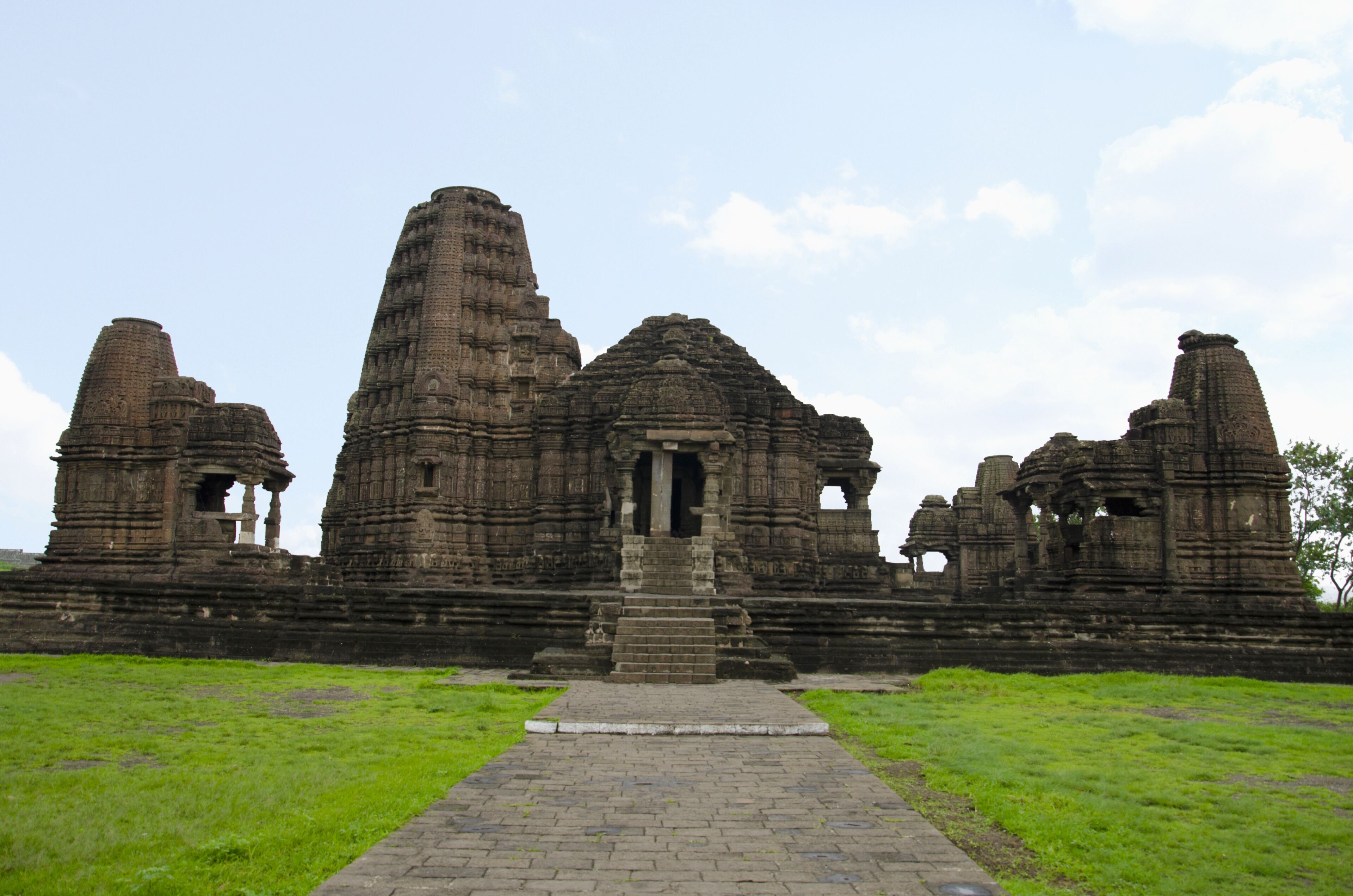 An ancient temple complex with multiple stone structures and a central doorway.