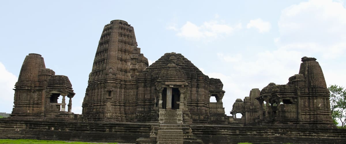 An ancient temple complex with multiple stone structures and a central doorway.