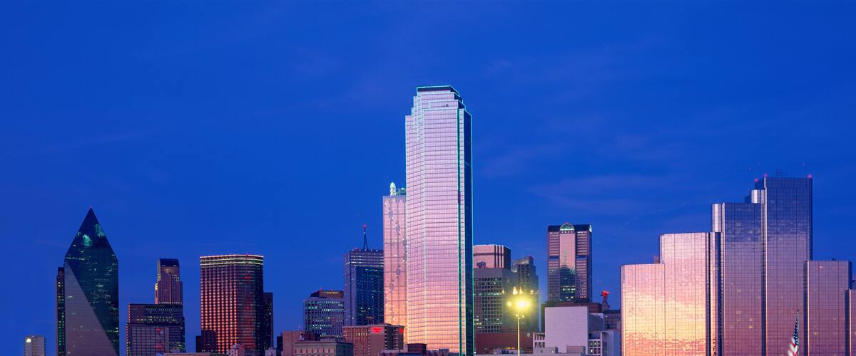 A city skyline with modern skyscrapers and a distinctive tower with a spherical top.