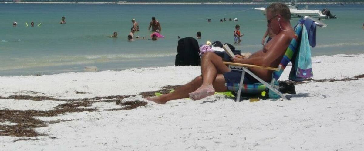 A beach with people swimming and sunbathing.