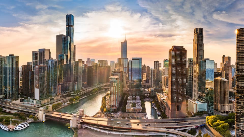 A city skyline with modern skyscrapers, a river, and a marina.
