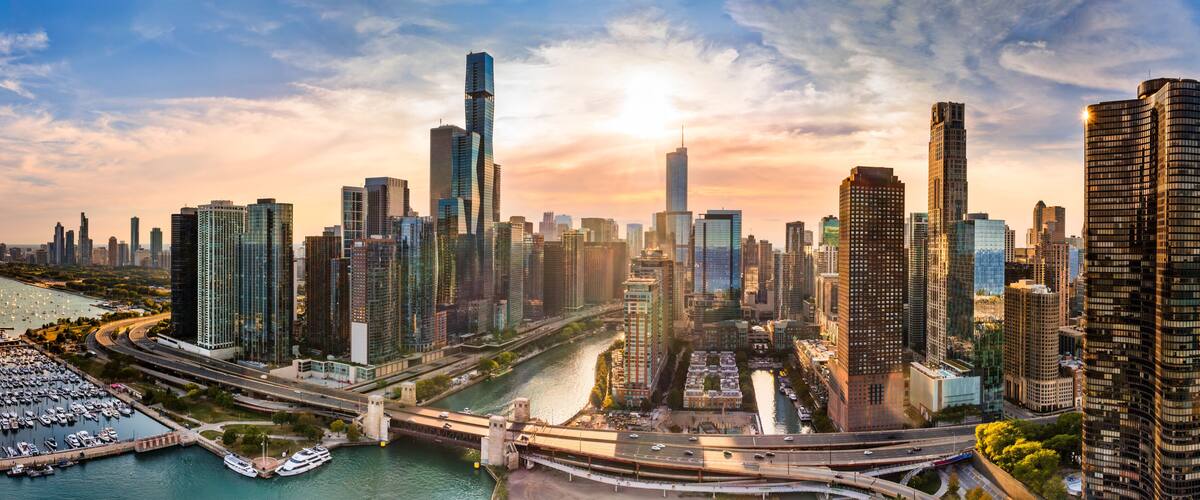 A city skyline with modern skyscrapers, a river, and a marina.