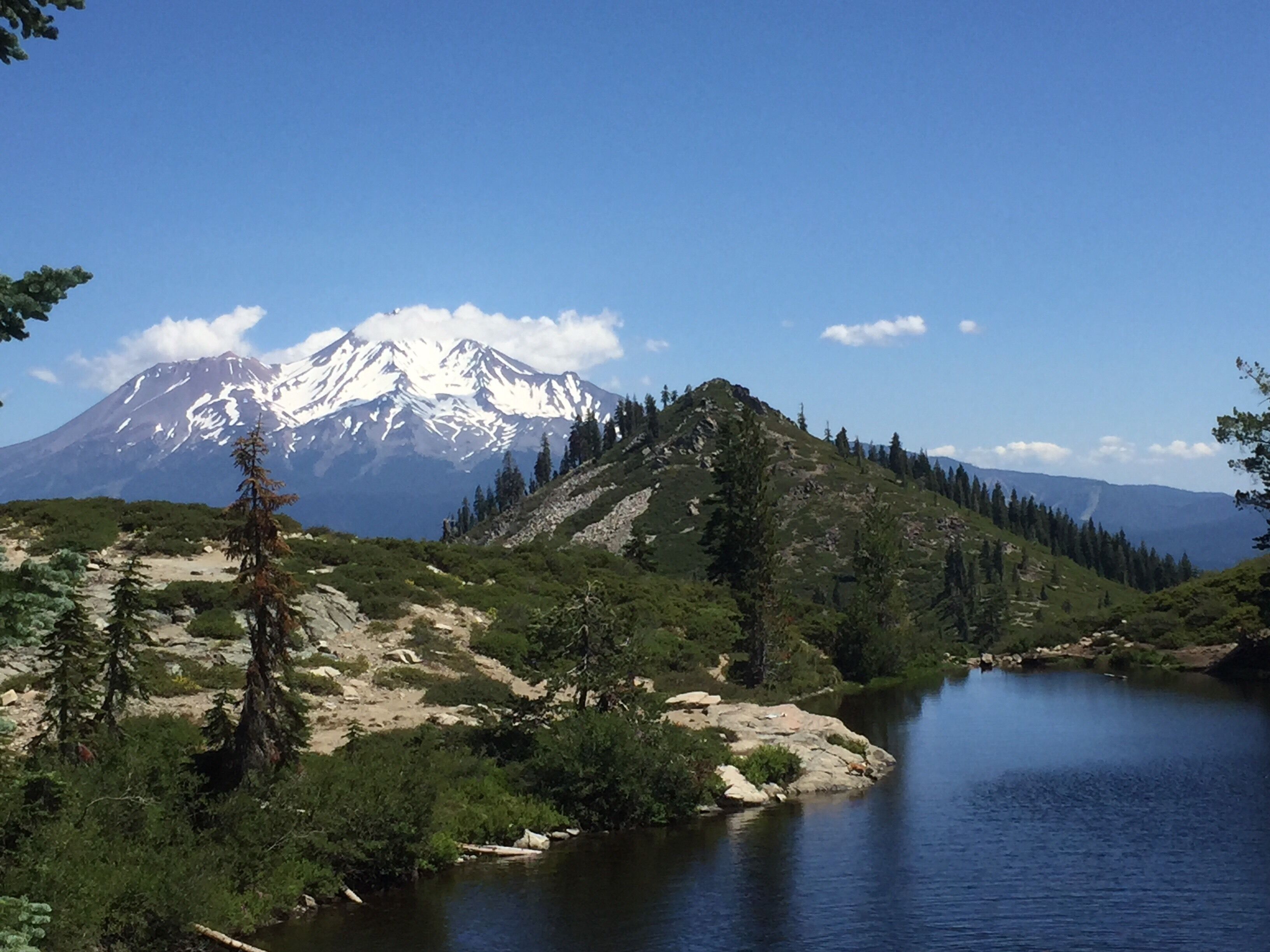 Lovely alpine lake that is shaped like a heart, looking out on Mt. Shasta.