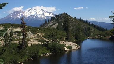 A lake surrounded by mountains and trees.