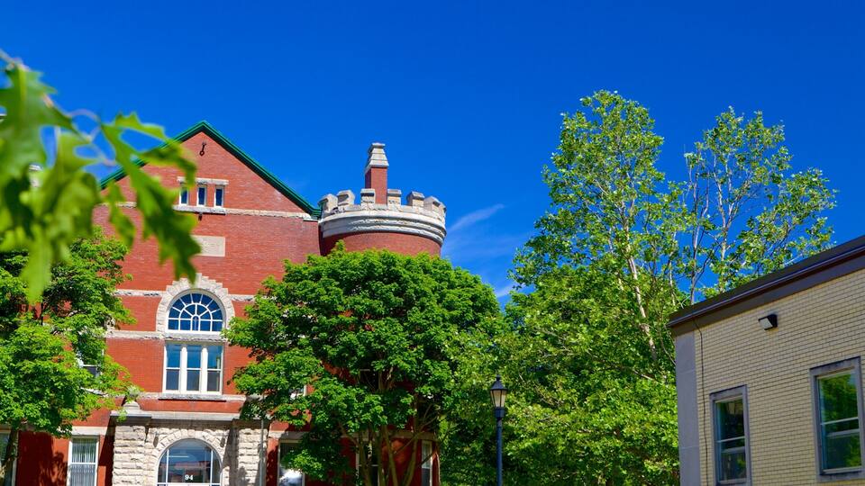 A red brick building with a turret and arched windows.