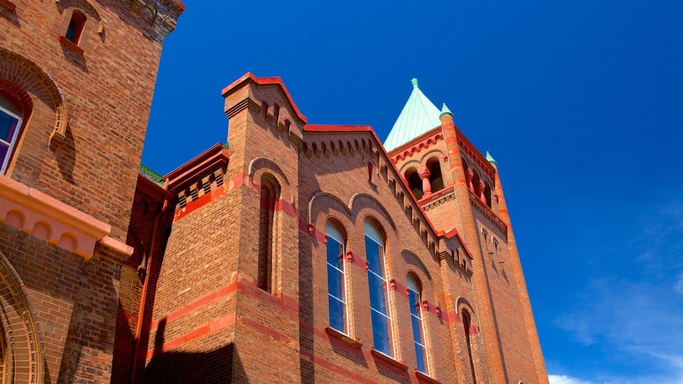A historic brick building with arched windows and a tower.