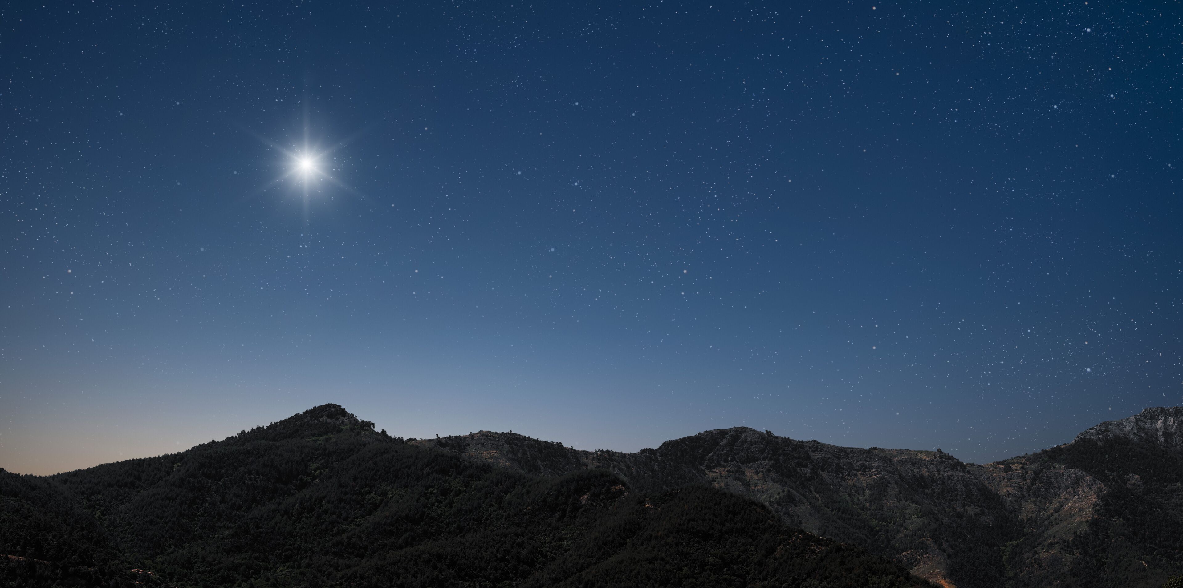 a Christmas star shines at night over the mountains of Bethlehem