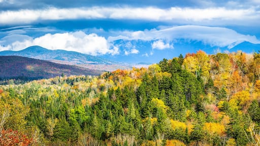 Panoramic view of New Hampshire fall foliage colors with clouds covered Mount Washington, in the background, as viewed from Bethlehem's NH Main street, on a sunny afternoon