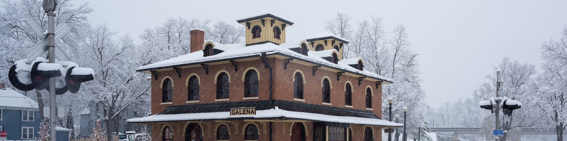 En historisk murstensbygning med et tag dækket af sne og skiltet 'GALENA' foran.